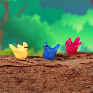 Three colorful resin hummingbird figurines resting on a tree branch for moss micro landscape