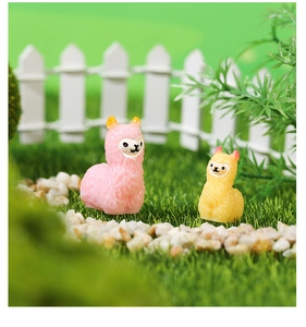 Macro shot of mini resin alpaca figurines on artificial grass for DIY garden decor