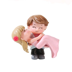 Romantic couple figurine wedding cake topper with boy hugging girl in pink dress