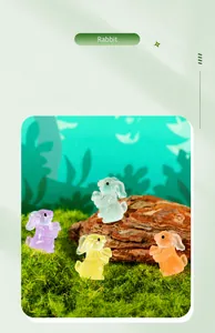 Close-up of four colorful miniature luminous rabbit figurines on natural moss decor