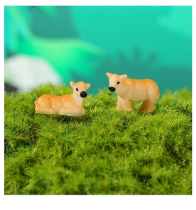 Detailed view of yellow resin deer figurines set in a lush green moss garden landscape