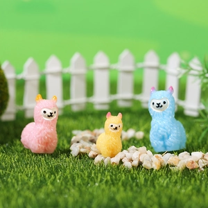 Three colorful alpaca figurines in a miniature moss landscape garden setting