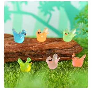 Miniature luminous hummingbird resin figurines with sunglasses on artificial moss background