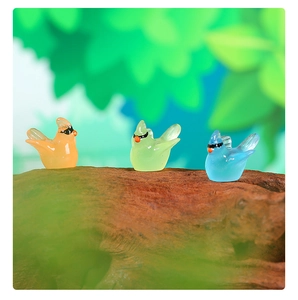 Macro shot of colorful translucent resin hummingbird figurines on natural wood bark texture