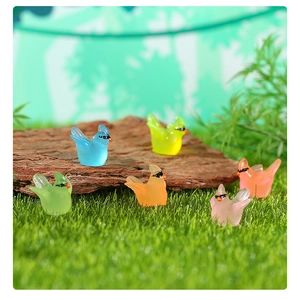 Miniature luminous resin hummingbirds with sunglasses on faux grass and bark detail
