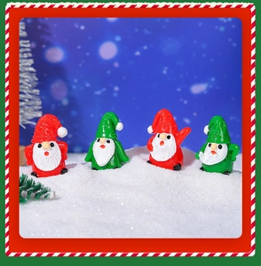 Detailed view of four mini Christmas gnome figurines on snow background