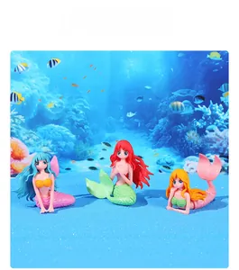 Detailed view of creative mermaid figurines with glitter accents in a blue sea setting