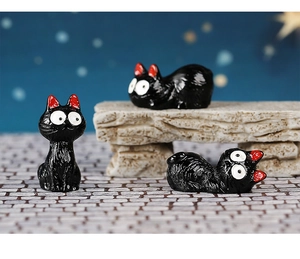 Macro view of three miniature black resin cats for Halloween fairy garden decor
