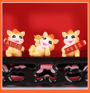 Close-up of yellow resin horse figurines with success and joy scrolls on wooden stand