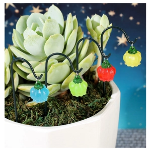 Detail of colorful luminous lantern flower charms hanging on a metal rack in garden scene