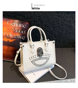 Detail of white PU leather tote bag featuring a rhinestone skull and metallic studs