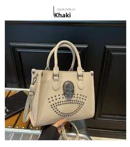 Detail of khaki tote bag featuring rhinestone skull and metallic stud embellishments
