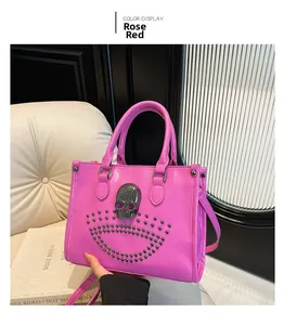 Detail of rose red handbag featuring metallic skull emblem and silver studded accents