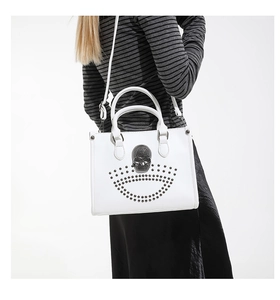 Detail of white box tote bag with black 3D skull and metallic punk rivet decoration