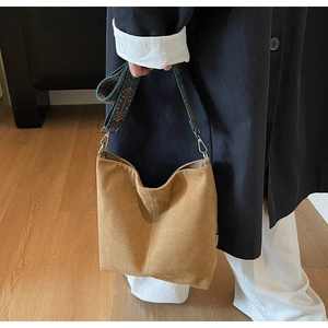 Detail view of brown suede hobo bag with ethnic pattern wide shoulder strap