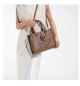 Detail shot of brown leather punk tote with silver skull and rivet stud embellishments