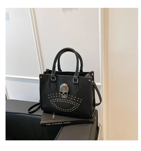 Détail du sac cabas noir avec emblème de crâne argenté et motifs de rivets cloutés