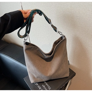 Detail of a brown canvas hobo bag with an adjustable ethnic embroidered shoulder strap