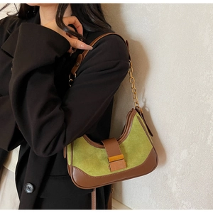 Close-up of avocado green suede hobo bag with contrast leather trim and golden metal clasp