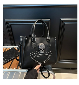 Détail du cabas noir avec emblème de crâne en strass et rivets argentés sur cuir texturé