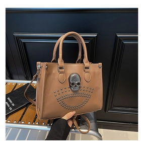 Détail du sac à main en cuir mat marron avec crâne métallique et rivets argentés élégants