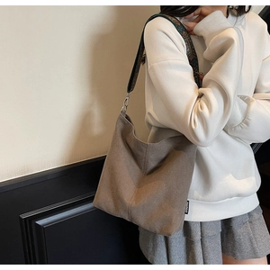 Brown canvas hobo bag featuring a vintage jacquard wide strap and side brand label