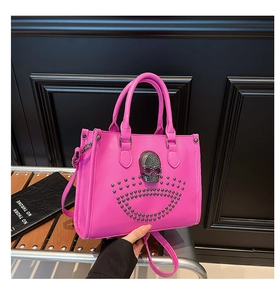 Détail du sac fourre-tout rose avec tête de mort en métal et rivets style punk