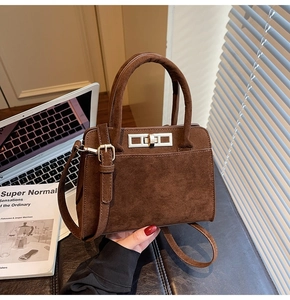 Detailed macro view showing dark brown suede texture and metal twist lock on the handbag