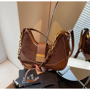 Detail of a brown half-moon underarm bag with gold chain and mixed textures