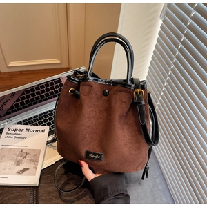 Détail du sac seau vintage en daim marron avec bandoulière en cuir noir et marquage