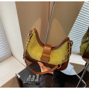 Detail of green suede and brown leather patchwork on vintage crescent shoulder bag