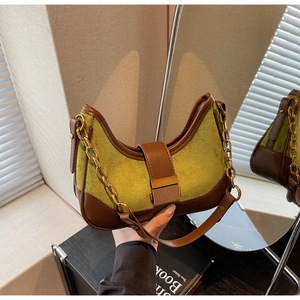Detail of crescent shoulder bag featuring green suede texture and brown trim with gold chain