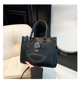 Détail d'un sac cabas noir avec motif tête de mort en diamant et clous métalliques