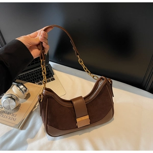 Detail of vintage brown suede shoulder bag with gold chain and metal buckle closure
