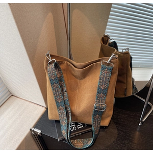 Detail view of canvas bucket bag with vintage ethnic print wide shoulder strap and metal buckle