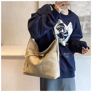Mirror selfie showing a large khaki frosted hobo bag with a decorative bow detail