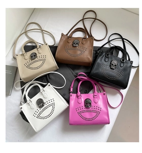 Vue à plat de cinq sacs cabas à rivets en beige, café, noir, blanc et rose avec crâne décoré