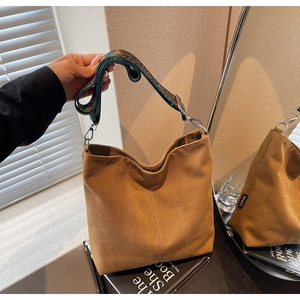Detail of canvas bucket bag showing jacquard strap and mirror reflection display