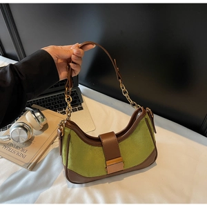 Detail of avocado green suede underarm bag with gold metal buckle and leather chain strap