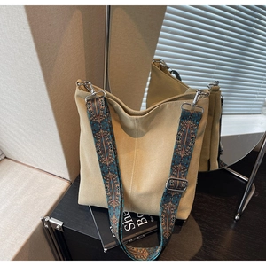 Detail of light khaki canvas bucket bag with vintage bohemian printed wide shoulder strap