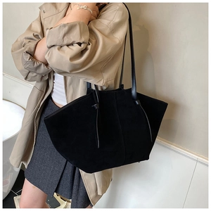 Détail d'un grand sac cabas noir mat en suédine avec de fines bandoulières élégantes