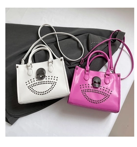 Détails des sacs fourre-tout blancs et rose vif avec rivets et crâne métallique