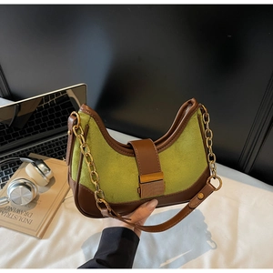 Detail of green suede moon bag with brown trim and vintage gold chain strap