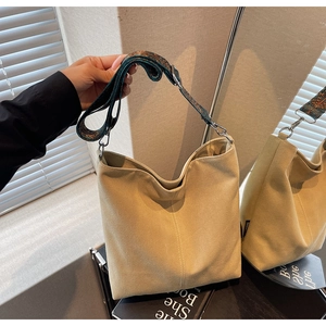 Detail of beige canvas bucket bag featuring a vintage ethnic floral embroidery wide strap