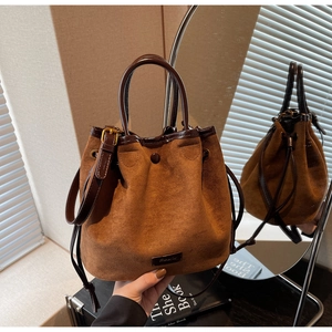 Détail du sac seau en daim caramel avec fermeture à cordon et texture cuir lisse