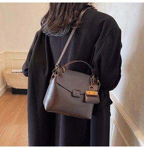 Detail view of a retro dark brown crossbody bag with mini pouch on a model