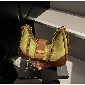 Detail of green suede and brown leather contrast on vintage hobo bag with gold chain