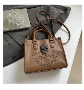 Détail du sac cabas marron avec un grand crâne métallique et des rivets argentés