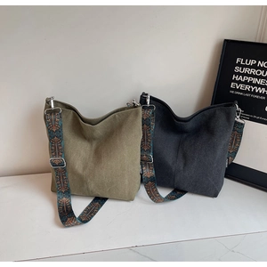 Detailed shot of olive green and charcoal canvas tote bags with ethnic woven straps