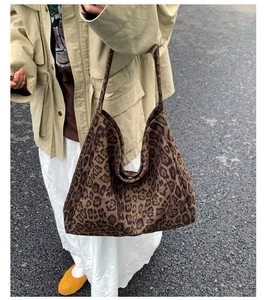 Detail of hobo leopard print tote bag styled with casual autumn beige trench coat